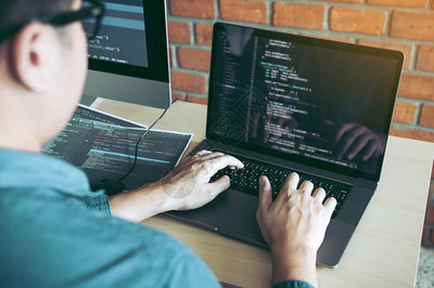 两名软件开发商正在使用计算机与其办公桌的合作伙伴